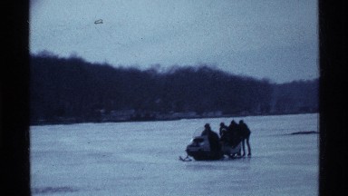 1969: a large group rides a snowmobile on chilly frozen lake OHIO