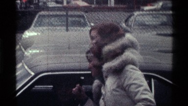 1976: Woman in White Coat Approaches Man's Car