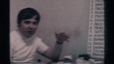 1976: Two Men Discussing a Large Board with Handwritten Letters