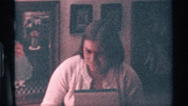 1976: a lady and two men are sitting around a table and the lady taking a file
