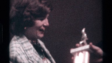 1976: a lady got her shield from a man and he kissed on her lips for celebrate
