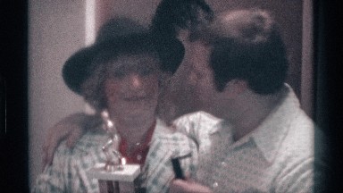 1976: a lady and women kiss each other and spread their love and another person