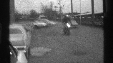 1976: a man standing to run the bike in road near steel back car blink the light