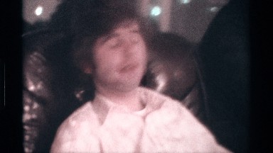 1976: Two Men Sitting on Couch Holding Up Four Fingers