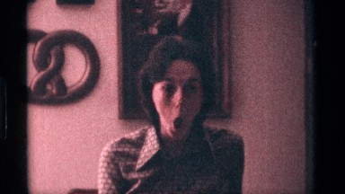 1976: woman looking at camera making silly faces then starts laughing. KENTUCKY