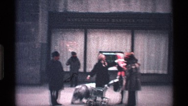 1971: man carries two children behind two women, a sheepdog and stroller