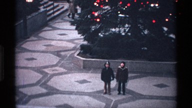 1971: two kids standing in front of a huge christmas tree and teasing each other