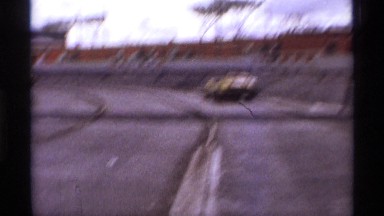 1974: car run the ground near to wall steps watch the people another side big