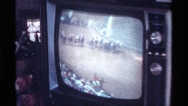 1976: a bunch of people are gathered together in a living room watching an event