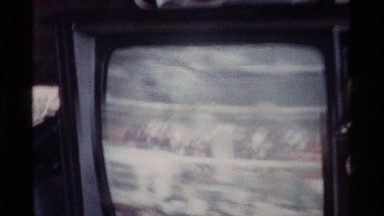 1976: the men and women watch the television horse match the men hand drink