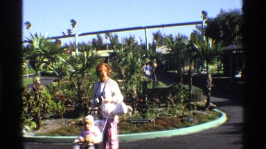 1969: Women Moving Baby Trolley with Child Inside and Watching Another Child