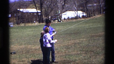 1969: father and kids trying to tie a thread for the kite. MICHIGAN