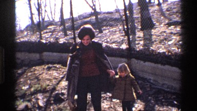 1969: mother and children walking around a park with big trees