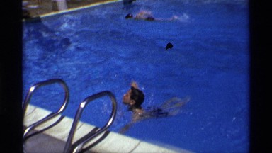 1971: a boy swimming at the swimming pool and turn his head then try to come out