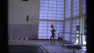 1971: a little girl jumps off a diving board in an indoor swimming pool NEW YORK