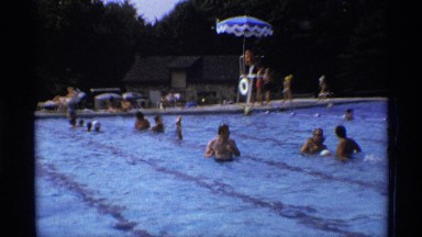 1971: man swimming in a public pool with otters around NEW YORK