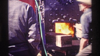 1969: a man put the wooden piece throw in the stove and the fire level