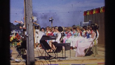 1969: a number of people are sitting in chairs listening to an elderly man speak