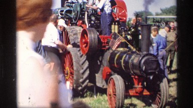 1969: the big tractor watch the people in the show near to green grasses tree