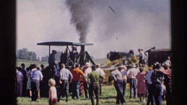 1969: Men Use Pitchforks to Throw Hay onto Conveyor Belt of Farm Machinery MABEL