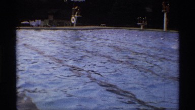 1971: people being filmed while having fun in the local pool on a hot summer day
