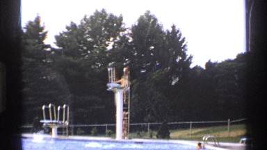 1971: A Swimmer Preparing to Take a Dive into a Pool from a Tall Diving Board