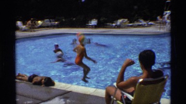 1971: kids enjoying an outdoor pool and a hot summer day with a cannon ball