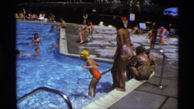 1971: many ladies and children are dive the swimming pool and enjoy the holidays