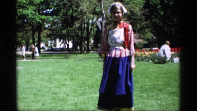 1969: girl dressed i. funny clothing with a women in the background picking