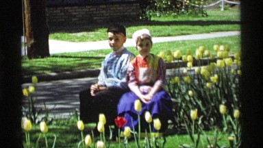 1969: well dressed children sitting in a flower garden posing for the camera.
