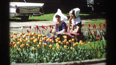 1969: two girls are sitting between the lawn surrounded by flowers HOLLAND