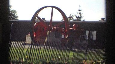 1969: a big wheel in the machine check men near to green grasses red color near