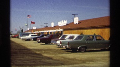 1969: car and transport are parking at a place and some flags also at the area