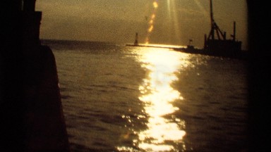 1969: ocean water shines in the evening time sunlight captured in lovely brown