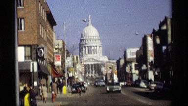 1966: cars are crossing beside of ancient monument building in a city