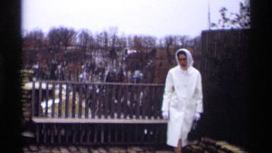 1966: a lady is walking slowly and she wear white dress