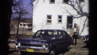 1966: man walks to car then put on hard hat. MADISON WISCONSIN