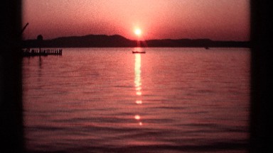 1969: sunrise in morning from mountain side containing small boat in middle