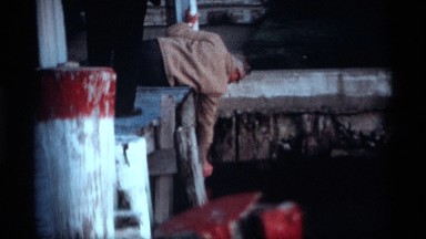 1969: older man carefully painting part of a pier HOLLAND MICHIGAN