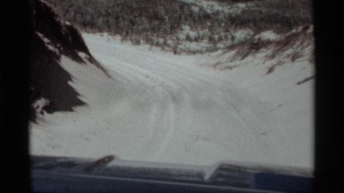 1969: a view of the snow filled road from the windshield of the vehicle