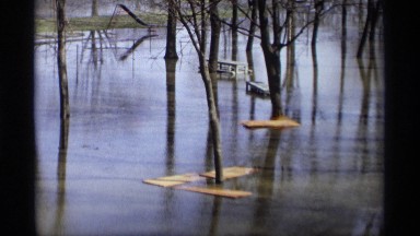 1969: four planks of wood sit on the surface of a barely frozen lake SAVAGE
