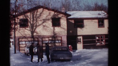 1968: three men are talking while they stand in a snow covered driveway CHICAGO