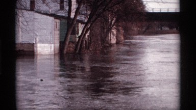 1969: street is flooded high with water reaching the steps of the houses