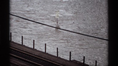 1969: flood waters rushing around a mile post sign. SAINT PAUL MINNESOTA
