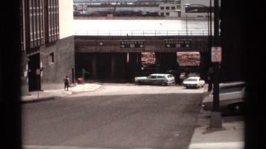 1969: big building near to lowest place car parking area near to wall morning
