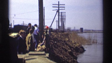 1969: construction workers working by the lakeside setting up powerlines