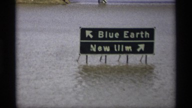 1969: two highway signs near new elm are submerged in water following a flood