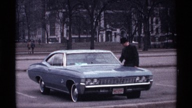 1968: man walks toward large, parked sedan CHICAGO ILLINOIS