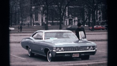 1968: man getting into the driver's seat of an old car CHICAGO ILLINOIS