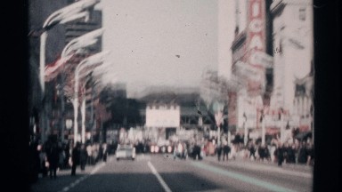 1968: a celebratory parade is taking place on a busy street where there are many